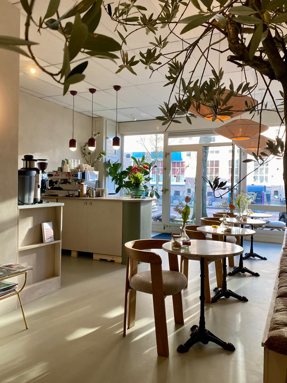 De koffiebar van HOMI met kleine tafeltjes en bloemen
