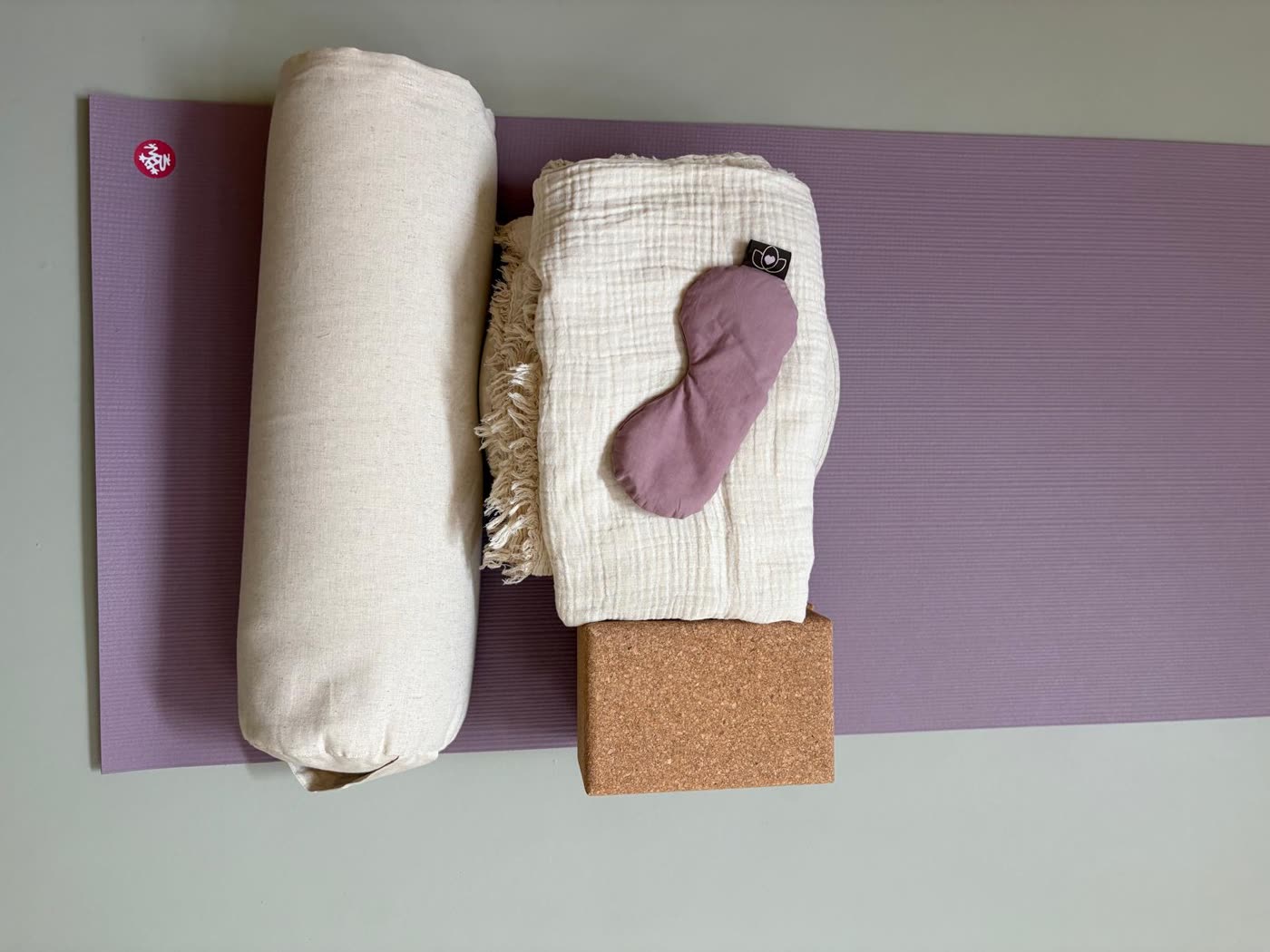 Een matje met bolster, deken, blok en oogmasker